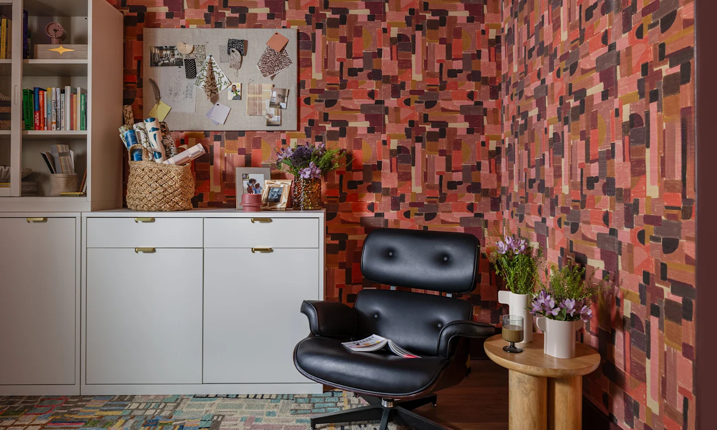 Home office space with pink and black geometric wallpaper.