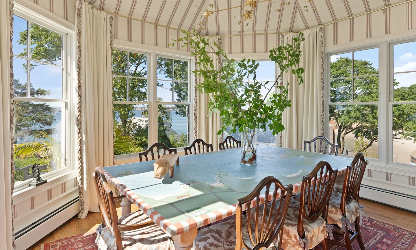 Dining area with tan and cream stripe wallpaper by Danika Herrick.