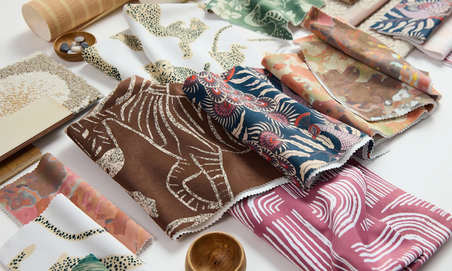 A mood board featuring an assortment of earth-toned fabrics, wallpaper samples, and drawings.