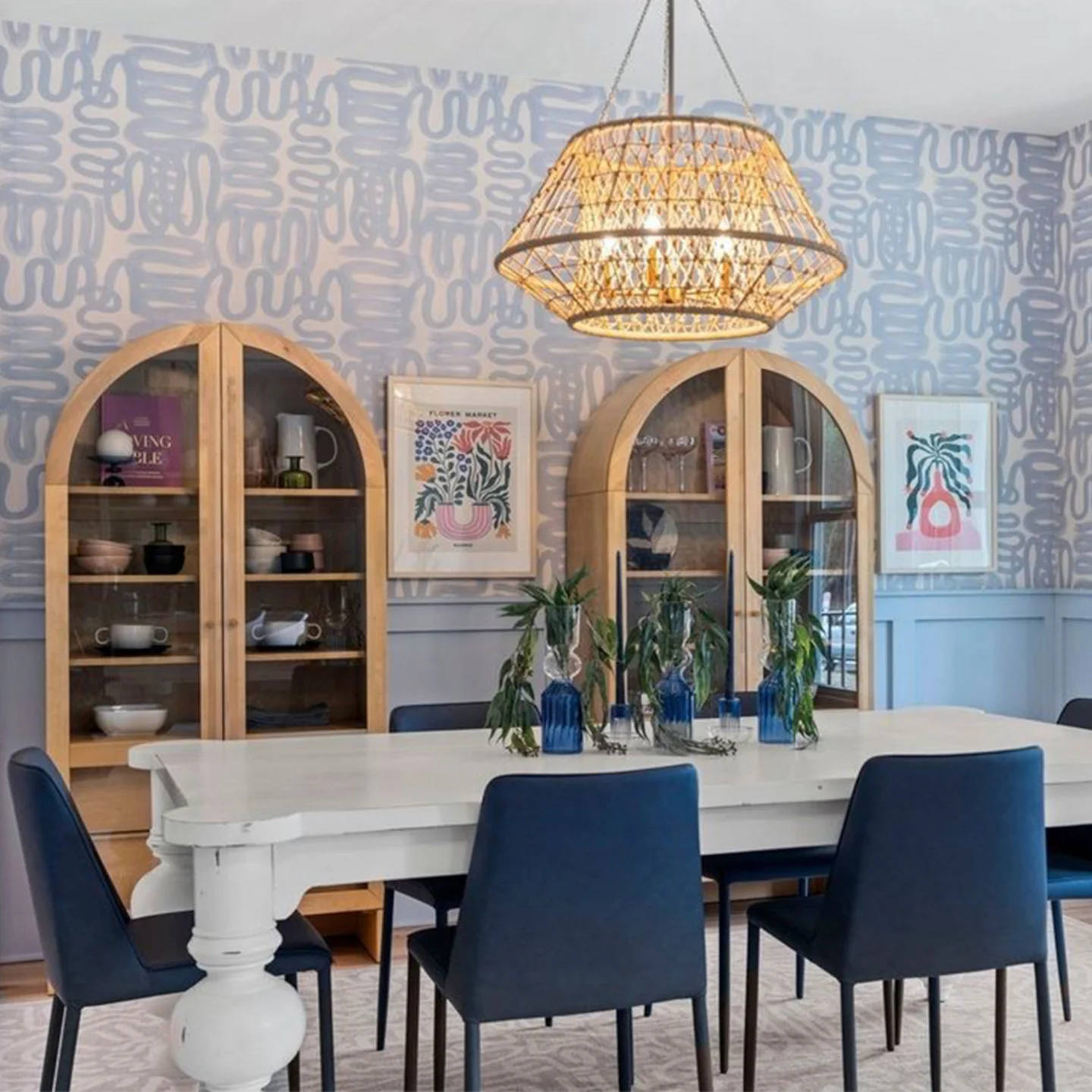Dining room with light blue squiggle wallpaper.