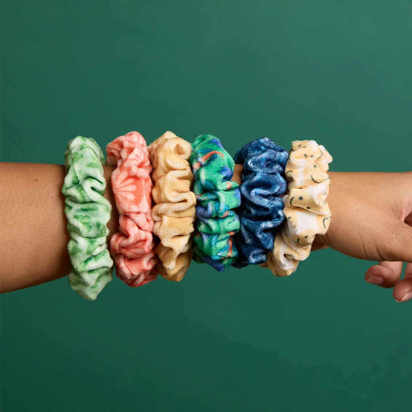 Back of girls head with hair pulled back by multiple colorful scrunchies.