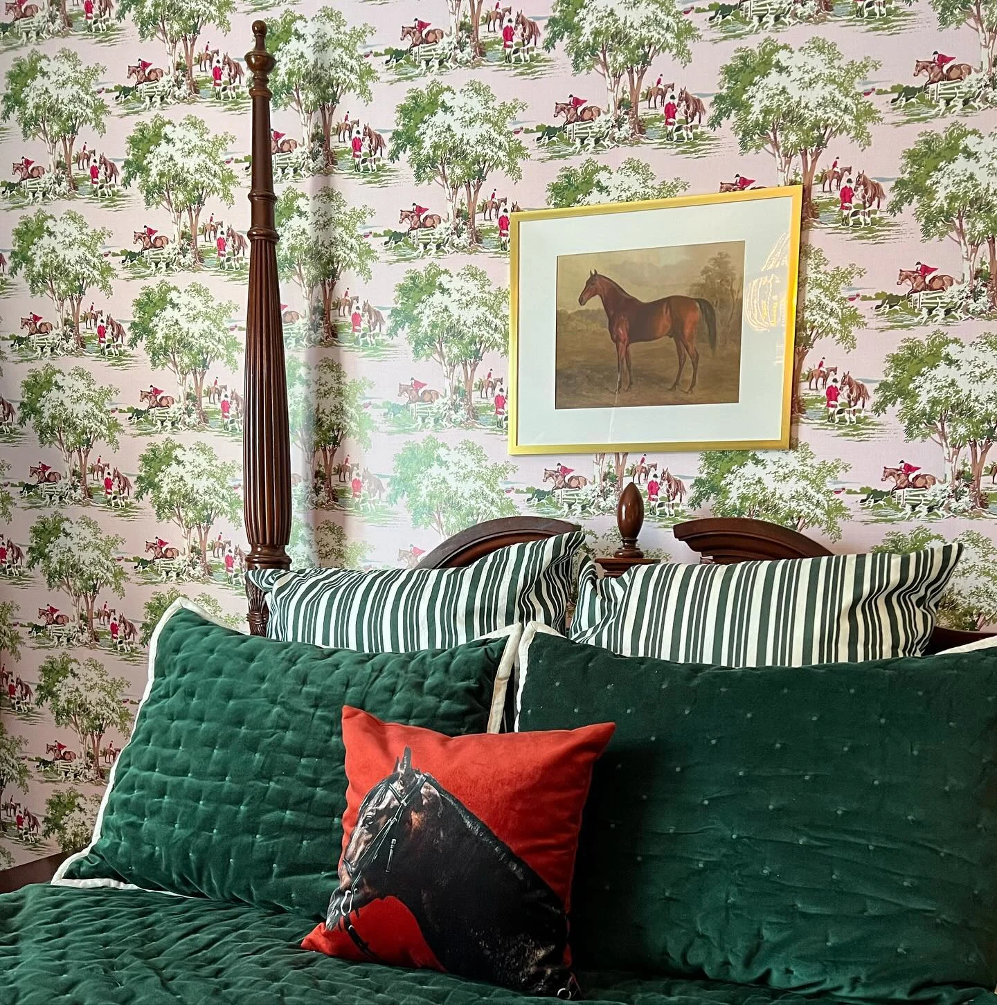 Bedroom with equestrian wallpaper and art.