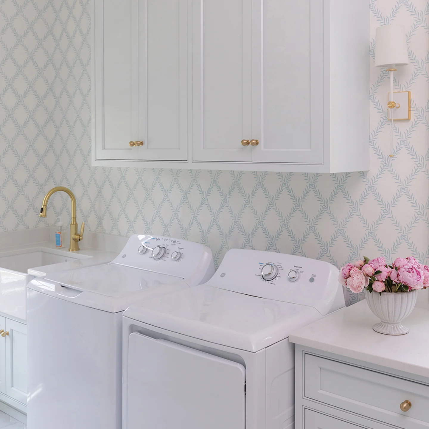 Laundry room with preppy trellis wallpaper.