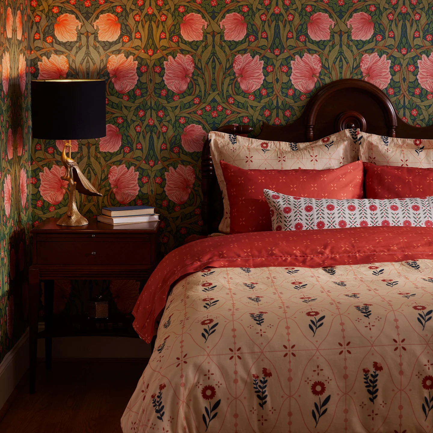 A traditional bedroom with sophisticated florals in pink, red, and beige.