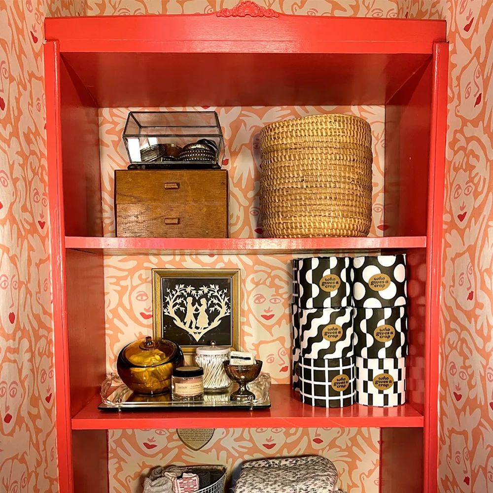 Peach face wallpaper behind a red shelf.